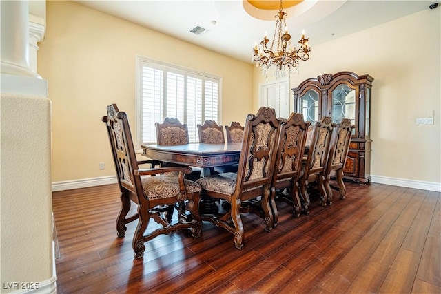 dining space with dark wood-type flooring and a chandelier