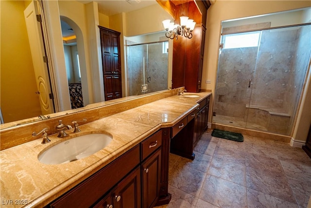 bathroom featuring vanity, a notable chandelier, and walk in shower