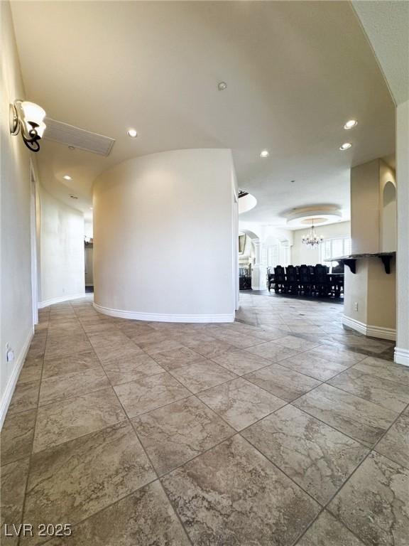 unfurnished room featuring a notable chandelier