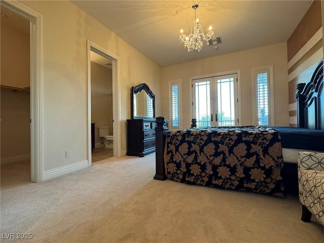 carpeted bedroom with access to exterior, french doors, a chandelier, and ensuite bathroom