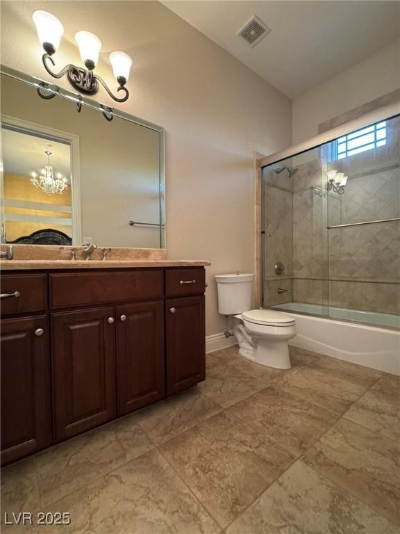 full bathroom featuring vanity, combined bath / shower with glass door, an inviting chandelier, and toilet