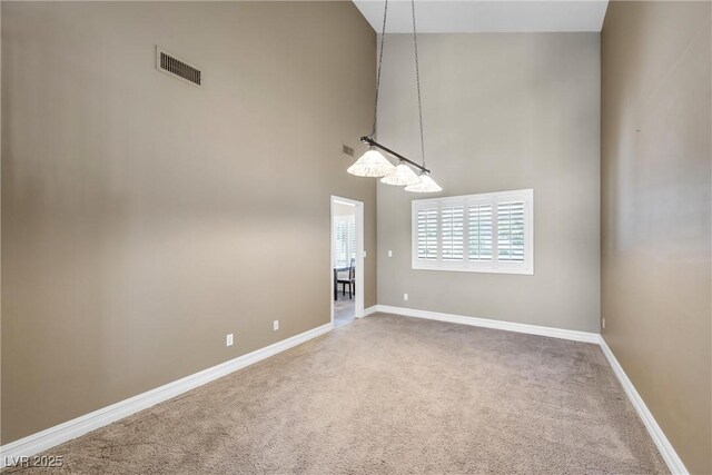 9435 Westwind Rd, Las Vegas, NV 89139 - unfurnished dining area featuring a towering ceiling, carpet flooring, and baseboards