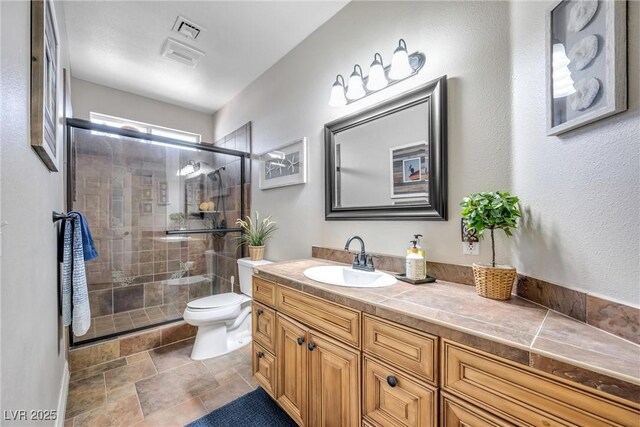 9435 Westwind Rd, Las Vegas, NV 89139 - full bathroom featuring toilet, vanity, a shower stall, and stone finish floors
