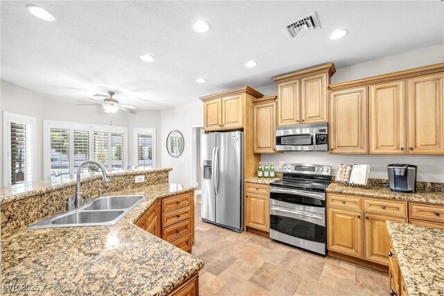 9435 Westwind Rd, Las Vegas, NV 89139 - kitchen featuring appliances with stainless steel finishes, a sink, recessed lighting, ceiling fan, and light stone countertops
