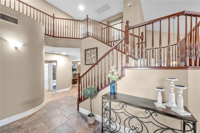 9435 Westwind Rd, Las Vegas, NV 89139 - staircase featuring baseboards, stone tile flooring, a towering ceiling, and recessed lighting