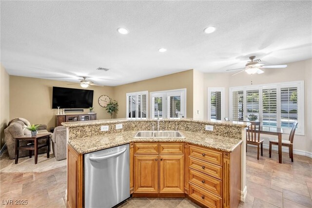 9435 Westwind Rd, Las Vegas, NV 89139 - kitchen featuring stainless steel dishwasher, a ceiling fan, a sink, healthy amount of natural light, and a textured ceiling