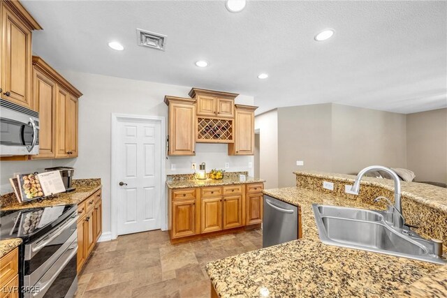 9435 Westwind Rd, Las Vegas, NV 89139 - kitchen with a sink, stainless steel appliances, recessed lighting, stone finish floors, and light stone countertops
