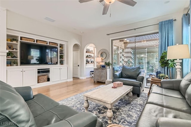 living room featuring ceiling fan, built in features, and light hardwood / wood-style floors