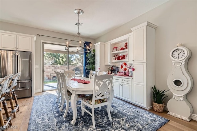 dining space featuring a chandelier and light hardwood / wood-style flooring