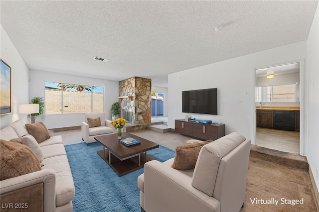 carpeted living room with sink and a textured ceiling