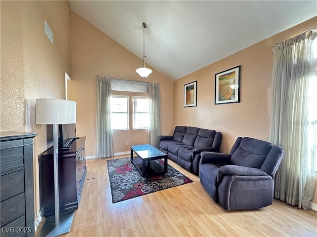 living room with light hardwood / wood-style flooring and high vaulted ceiling