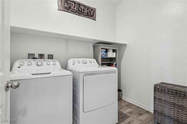 laundry room with washing machine and dryer and light hardwood / wood-style flooring