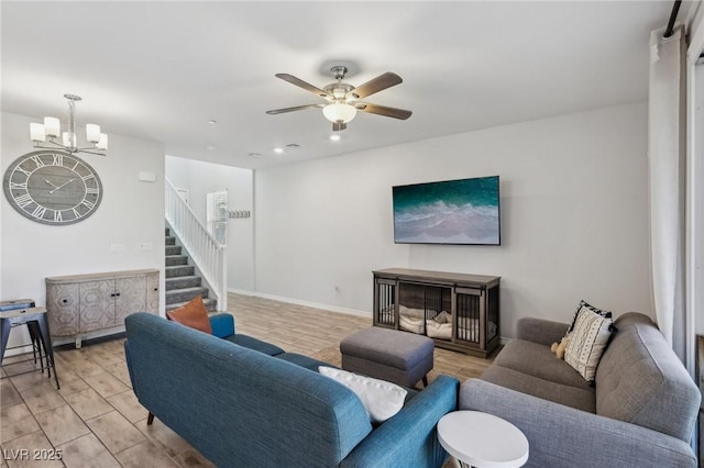 living room with ceiling fan with notable chandelier and light wood-type flooring