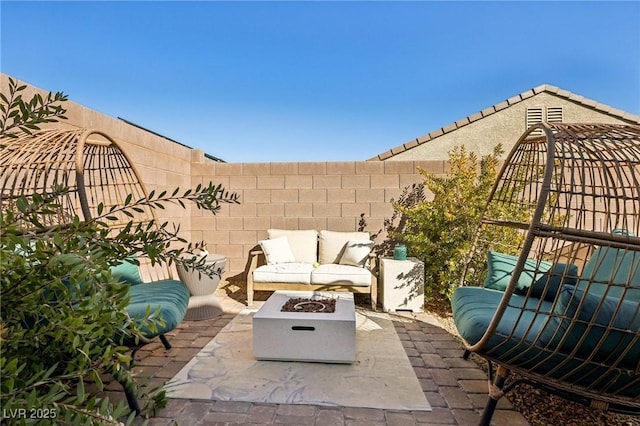 view of patio with an outdoor living space with a fire pit