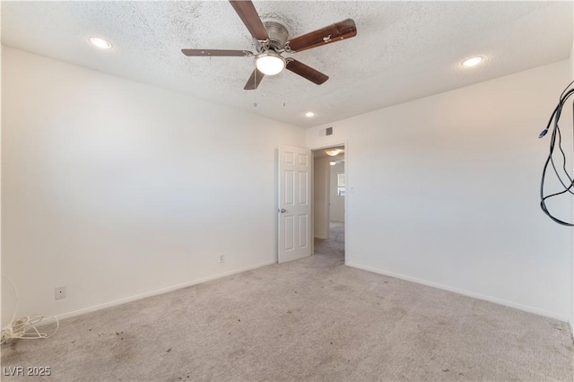 carpeted spare room featuring ceiling fan and a textured ceiling