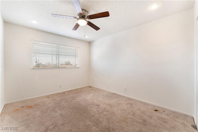 carpeted empty room featuring ceiling fan and a textured ceiling