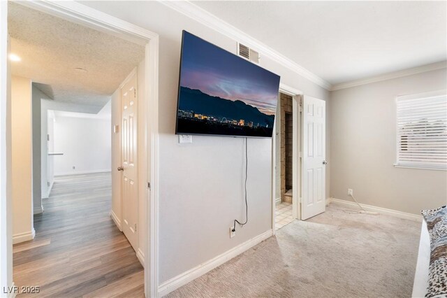 interior space featuring ornamental molding and light colored carpet