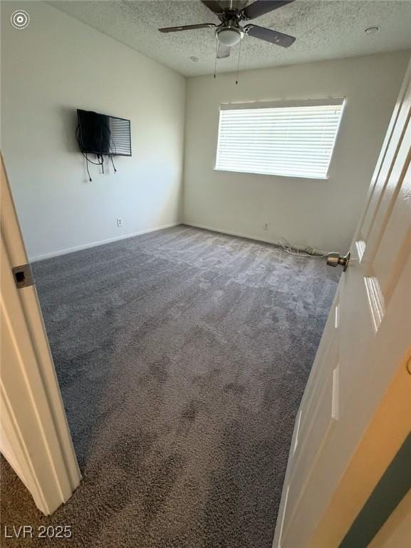 carpeted spare room featuring ceiling fan and a textured ceiling