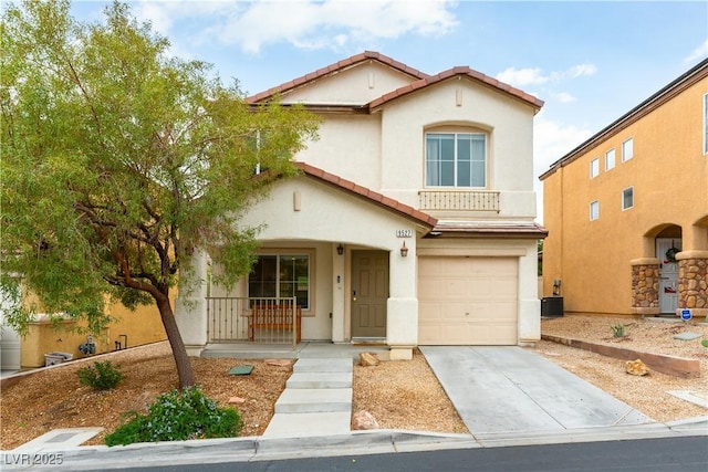 mediterranean / spanish home with a porch, concrete driveway, a tiled roof, and stucco siding