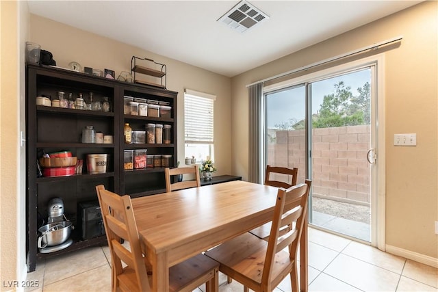 dining room featuring a healthy amount of sunlight, light tile patterned floors, baseboards, and visible vents