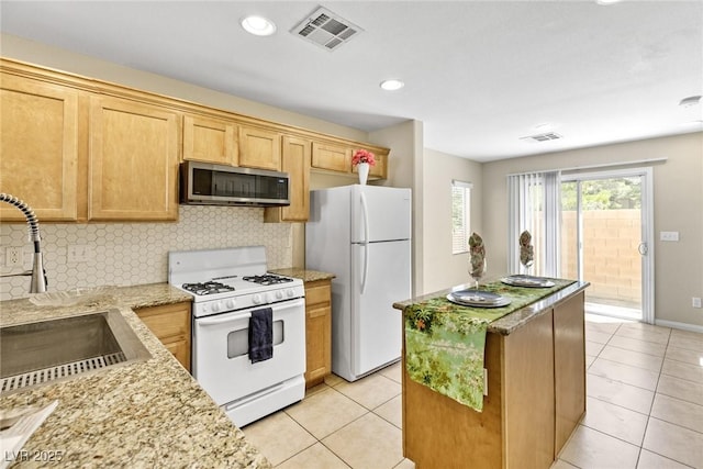 9527 Havasu Canyon Ave, Las Vegas, NV 89166 - kitchen featuring white appliances, light tile patterned floors, a kitchen island, backsplash, and light stone countertops