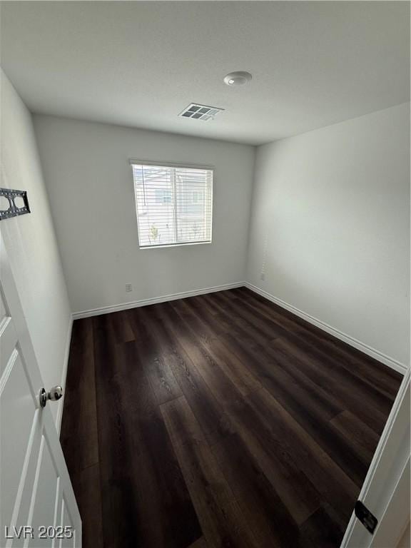 spare room featuring dark hardwood / wood-style flooring