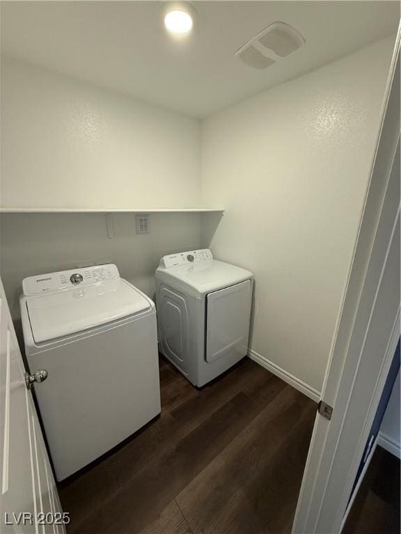 laundry area with washer and dryer and dark wood-type flooring