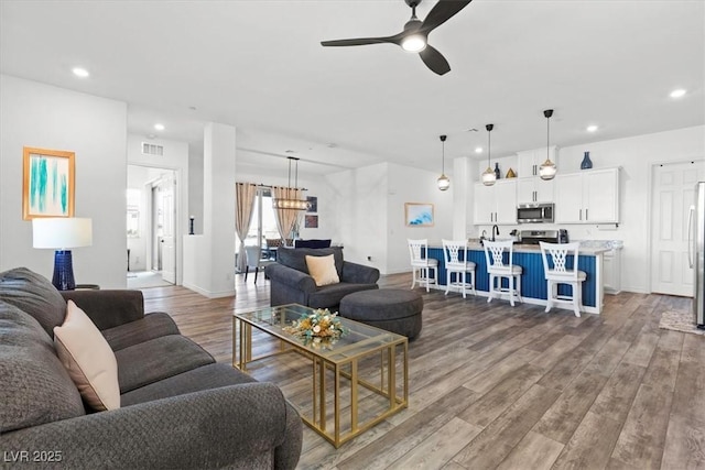 living room featuring hardwood / wood-style flooring and ceiling fan