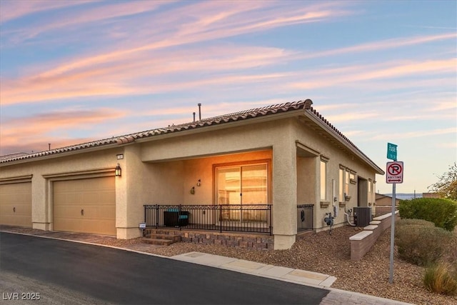 view of front of property featuring a garage and central AC unit