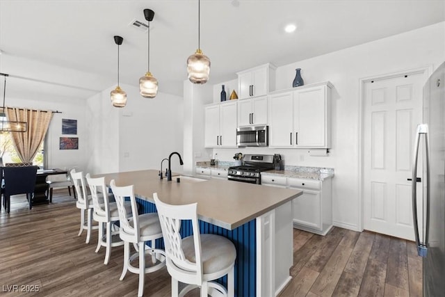 kitchen with stainless steel appliances, decorative light fixtures, sink, and white cabinets