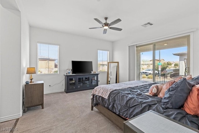 bedroom with multiple windows, access to outside, light colored carpet, and ceiling fan