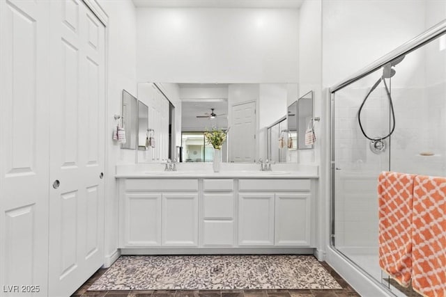 bathroom with a shower with door, vanity, and ceiling fan