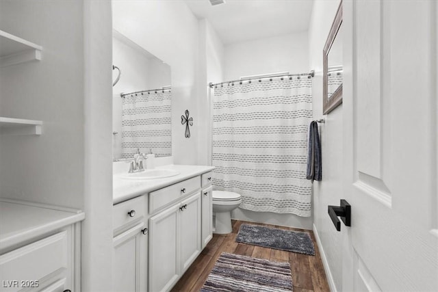 bathroom with hardwood / wood-style flooring, vanity, toilet, and walk in shower