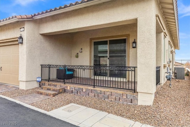 entrance to property with cooling unit and a garage