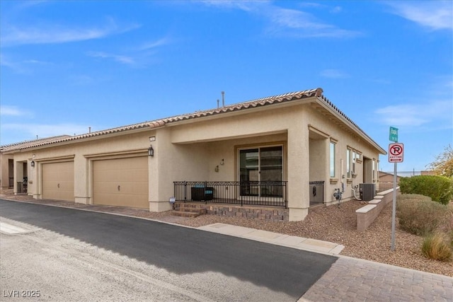 view of front of property featuring central AC unit and a garage