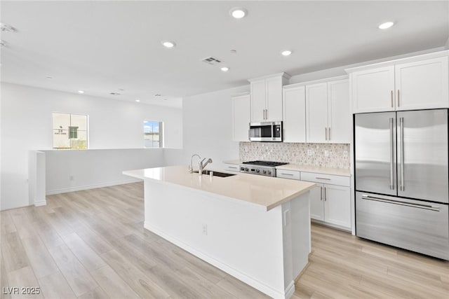 kitchen with white cabinetry, sink, a center island with sink, and appliances with stainless steel finishes