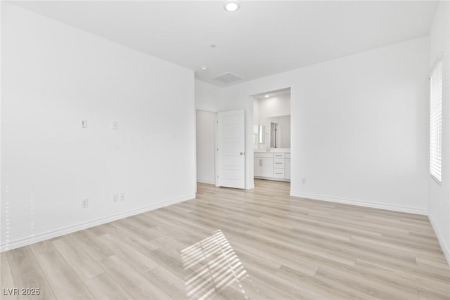 unfurnished bedroom featuring connected bathroom and light hardwood / wood-style flooring