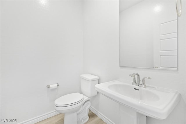 bathroom featuring wood-type flooring, toilet, and sink