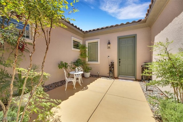 view of exterior entry with a patio