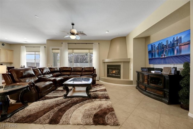 living room with ceiling fan, a fireplace, and light tile patterned floors