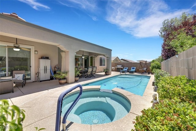 view of swimming pool featuring an in ground hot tub, ceiling fan, and a patio