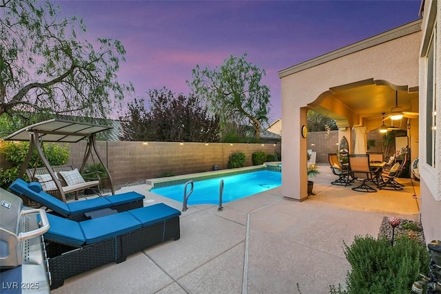 pool at dusk featuring a patio