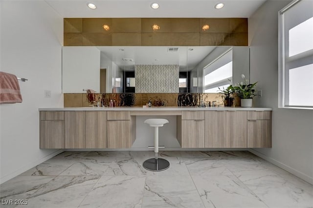 full bathroom featuring marble finish floor, double vanity, recessed lighting, and tasteful backsplash