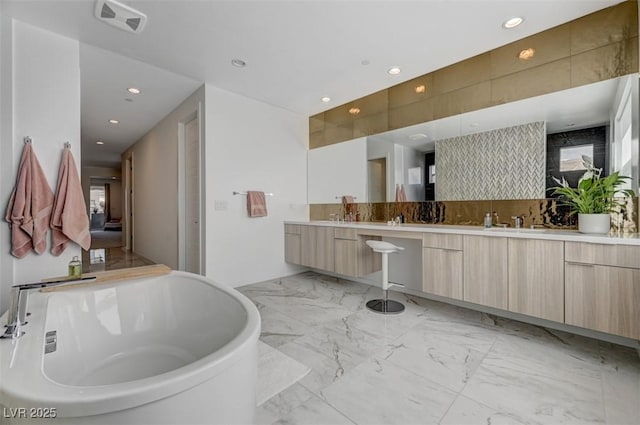 bathroom featuring marble finish floor, double vanity, recessed lighting, visible vents, and a freestanding tub