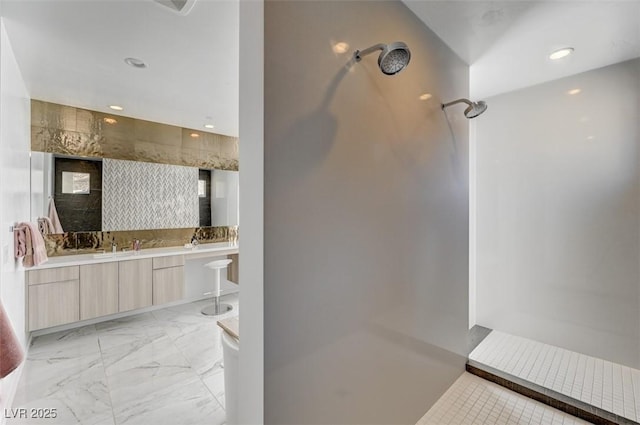 bathroom with double vanity, marble finish floor, a shower, and recessed lighting