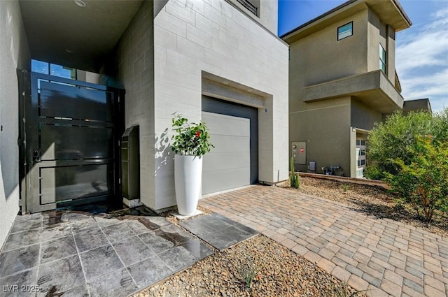 entrance to property with driveway and an attached garage