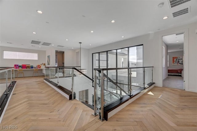 hall with recessed lighting, baseboards, visible vents, and an upstairs landing