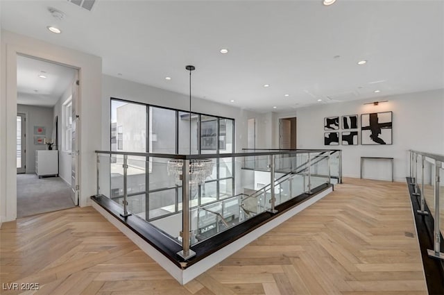 corridor featuring an upstairs landing and recessed lighting