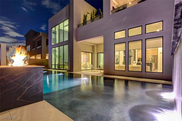 view of pool featuring an outdoor fire pit and a patio area