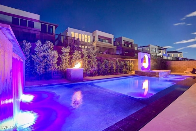 view of swimming pool with a pool with connected hot tub and fence